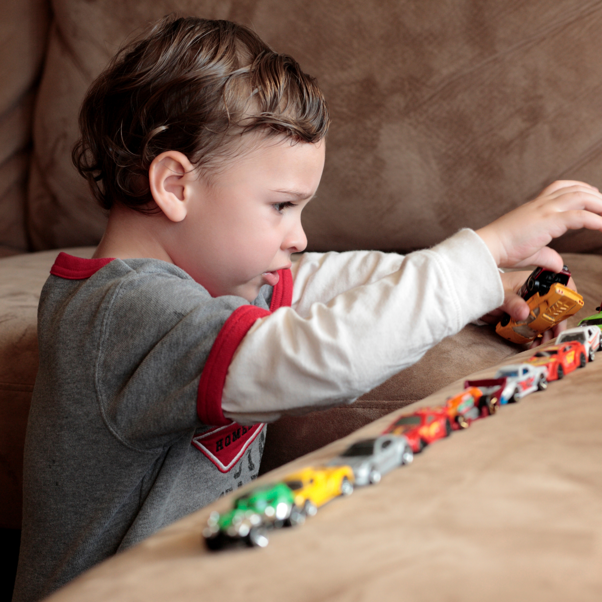 Child with hands on head as letters float nearby, suggesting learning overwhelm